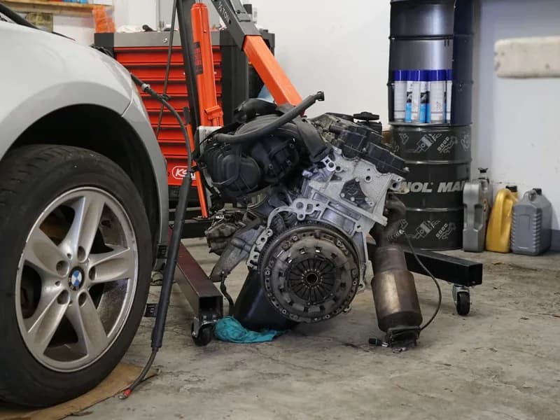 Ausgebauter Motor neben dem Fahrzeug